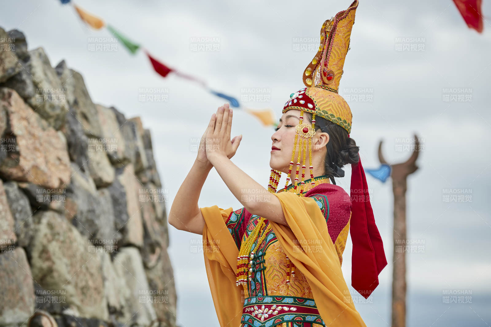 草原上敖包前身穿豪华蒙古族服饰的蒙族少女图片