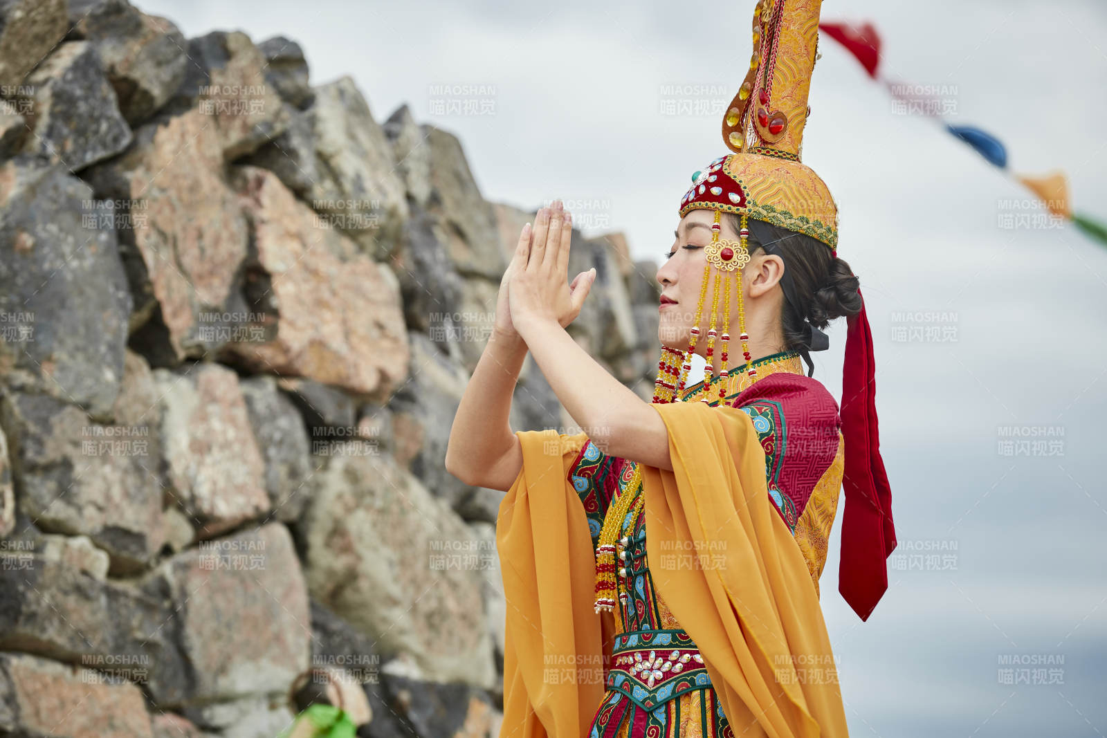 草原上敖包前身穿豪华蒙古族服饰的蒙族少女图片
