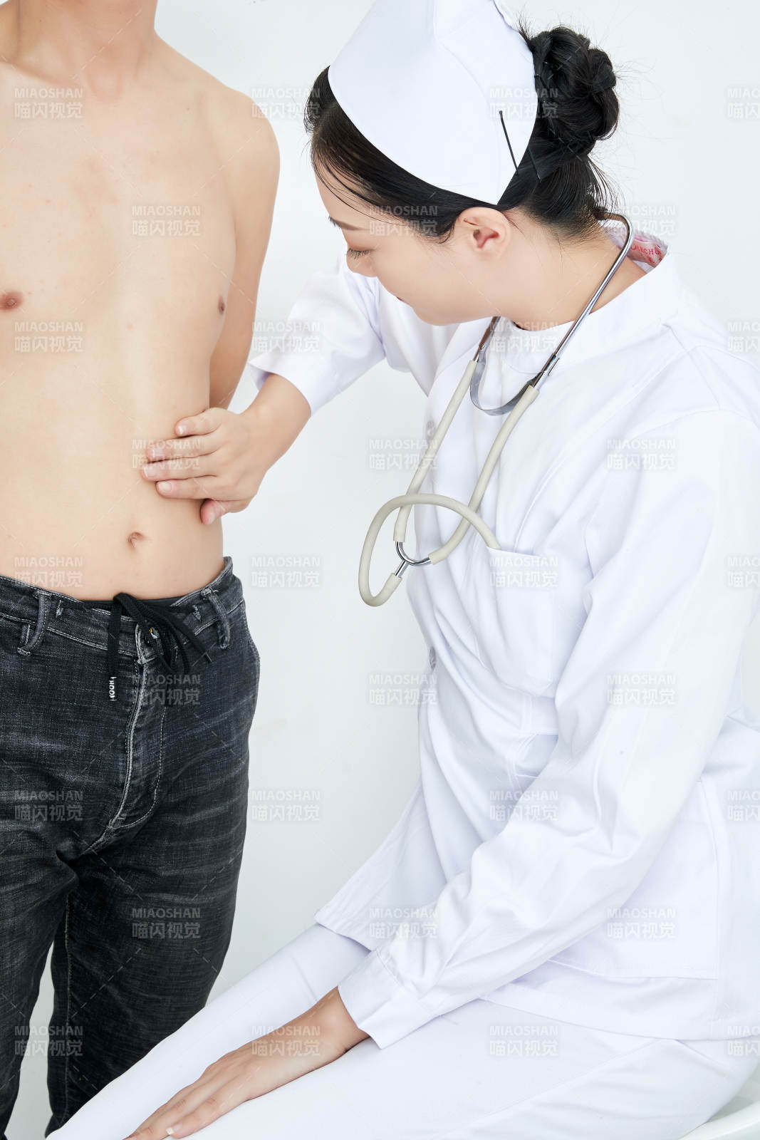 年轻的女性医护人员为患者进行身体按压检查图片