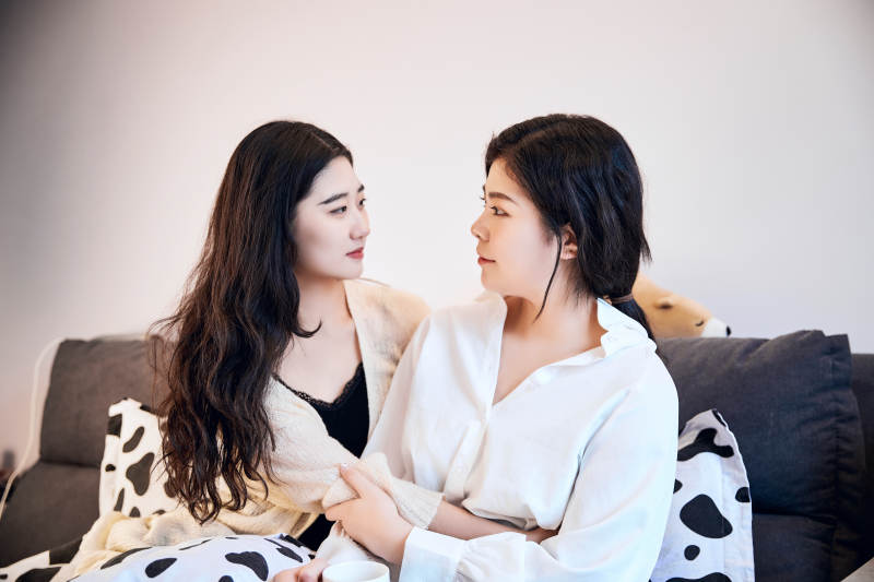 坐在床上玩耍的俩位年轻亚洲美女图片