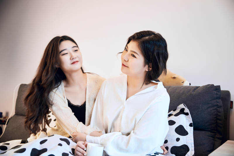 坐在床上玩耍的俩位年轻亚洲美女图片