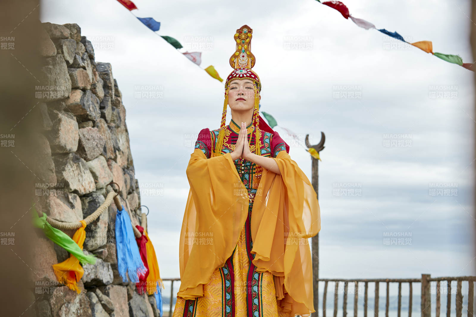 草原上敖包前身穿豪华蒙古族服饰的蒙族少女图片