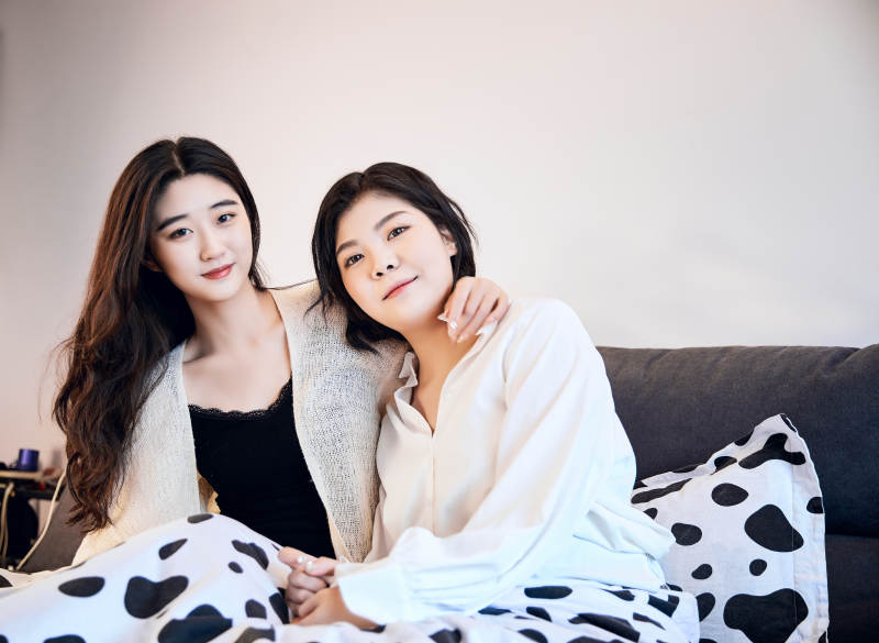 坐在床上玩耍的俩位年轻亚洲美女图片