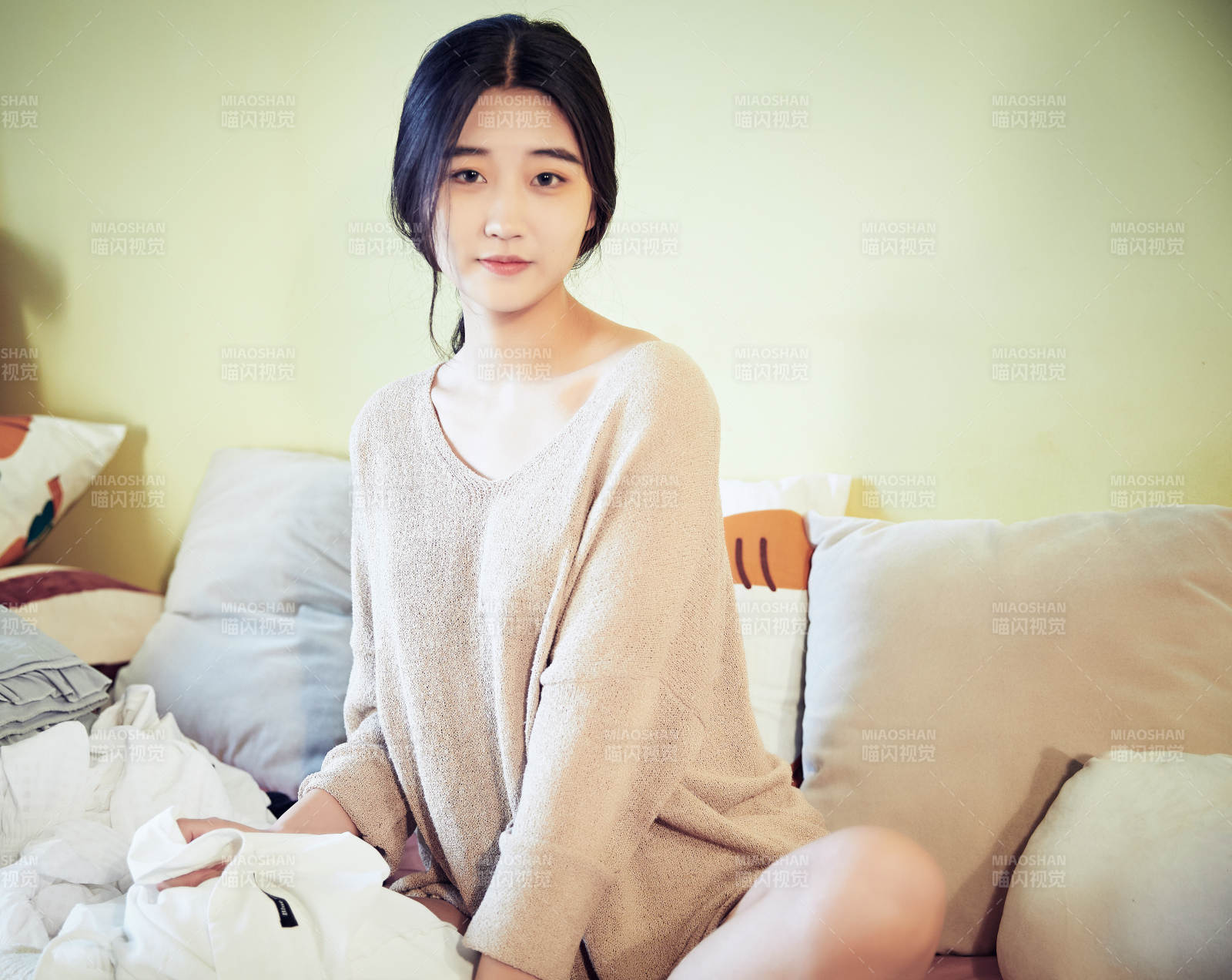 在沙发床上整理行装的年轻亚洲女性图片