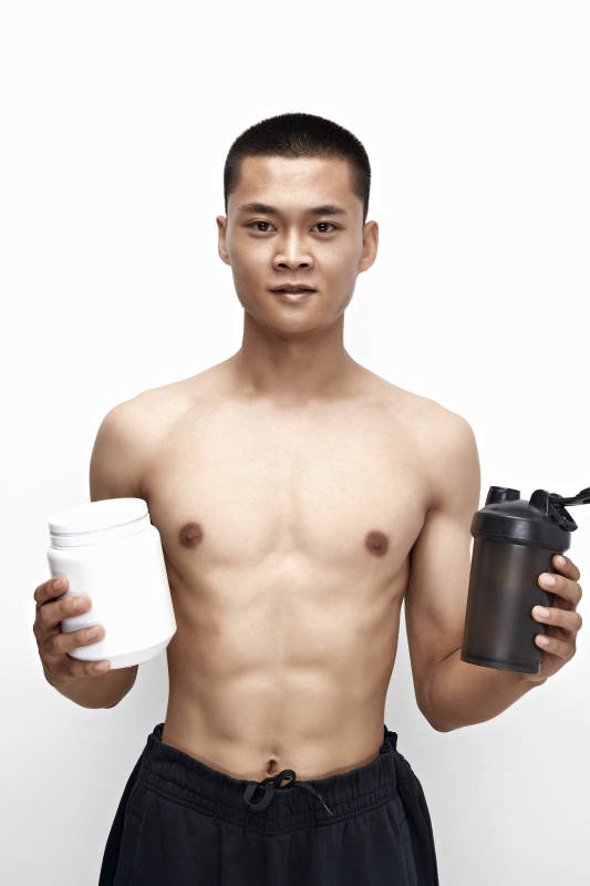 手持蛋白粉的身材匀称肌肉扎实的亚洲男性图片