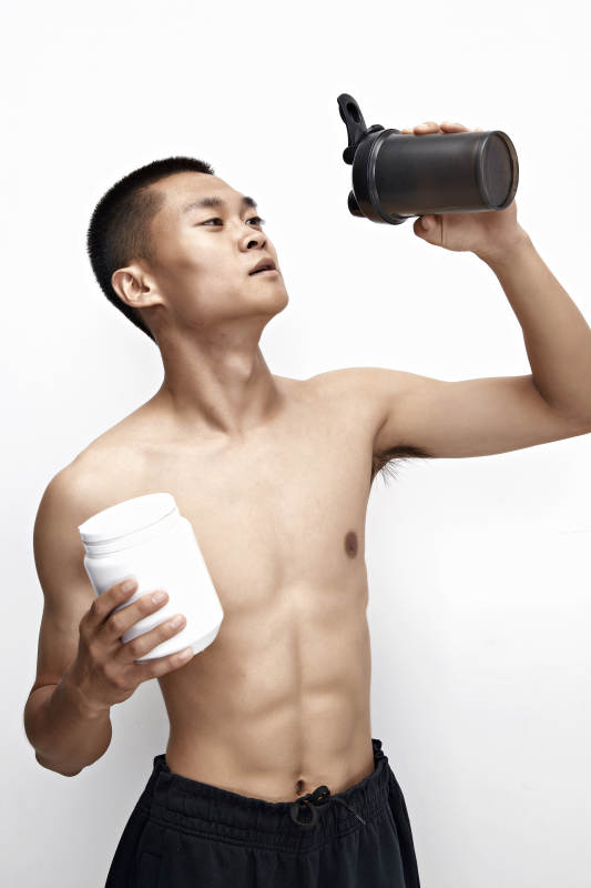 手持蛋白粉的身材匀称肌肉扎实的亚洲男性图片