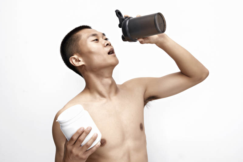 手持蛋白粉的身材匀称肌肉扎实的亚洲男性图片