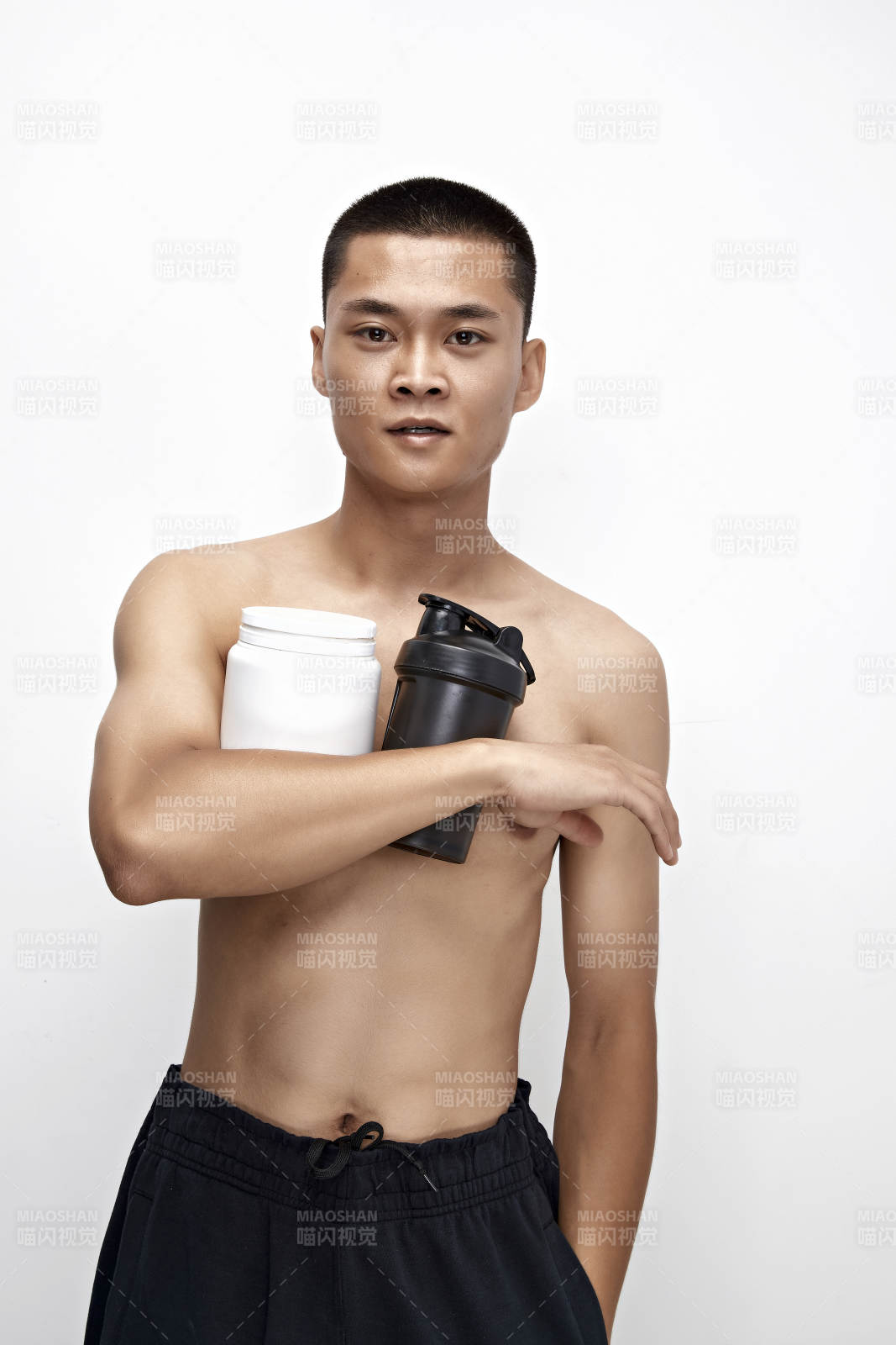 手持蛋白粉的身材匀称肌肉扎实的亚洲男性图片