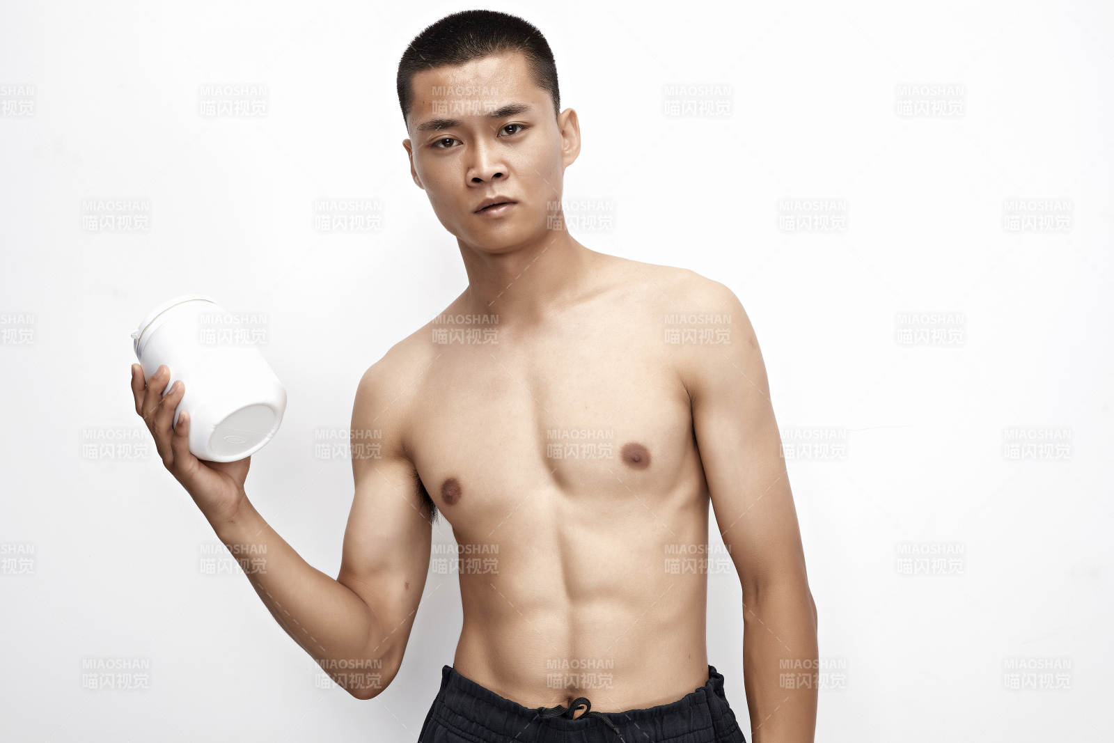 手持蛋白粉的身材匀称肌肉扎实的亚洲男性图片