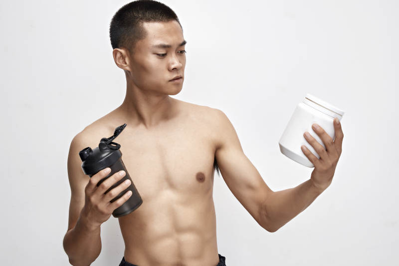 手持蛋白粉的身材匀称肌肉扎实的亚洲男性图片