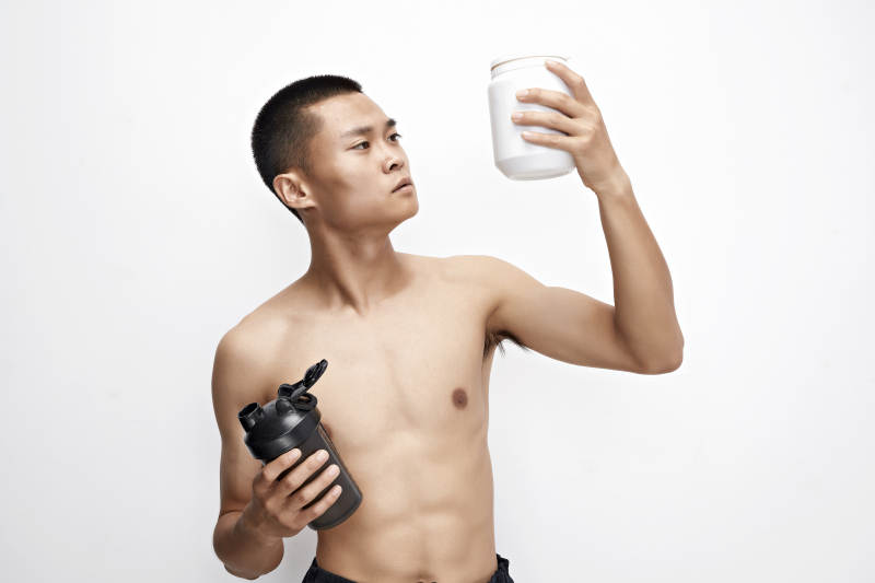 手持蛋白粉的身材匀称肌肉扎实的亚洲男性图片