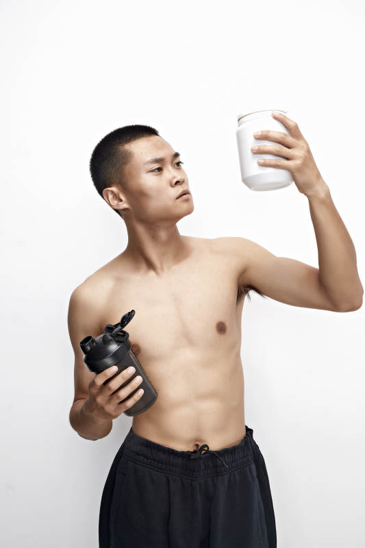 手持蛋白粉的身材匀称肌肉扎实的亚洲男性图片