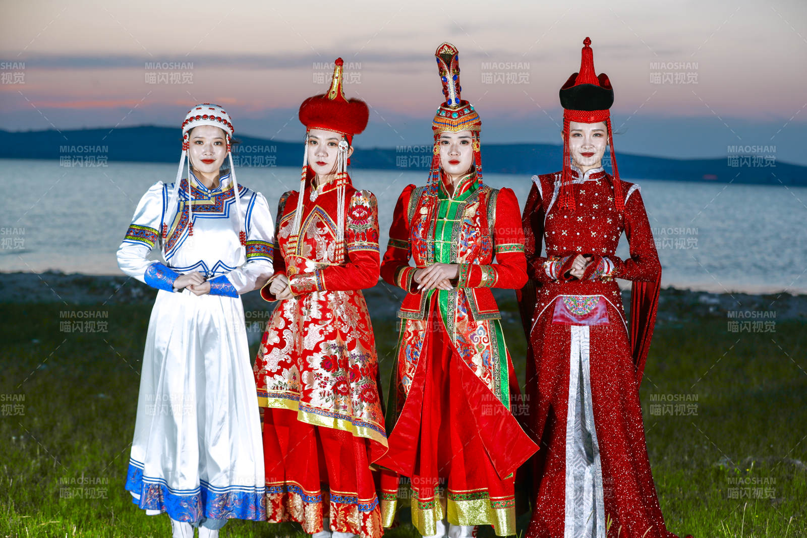 晚霞的草原湖畔穿蒙古族传统服饰的年轻女性图片