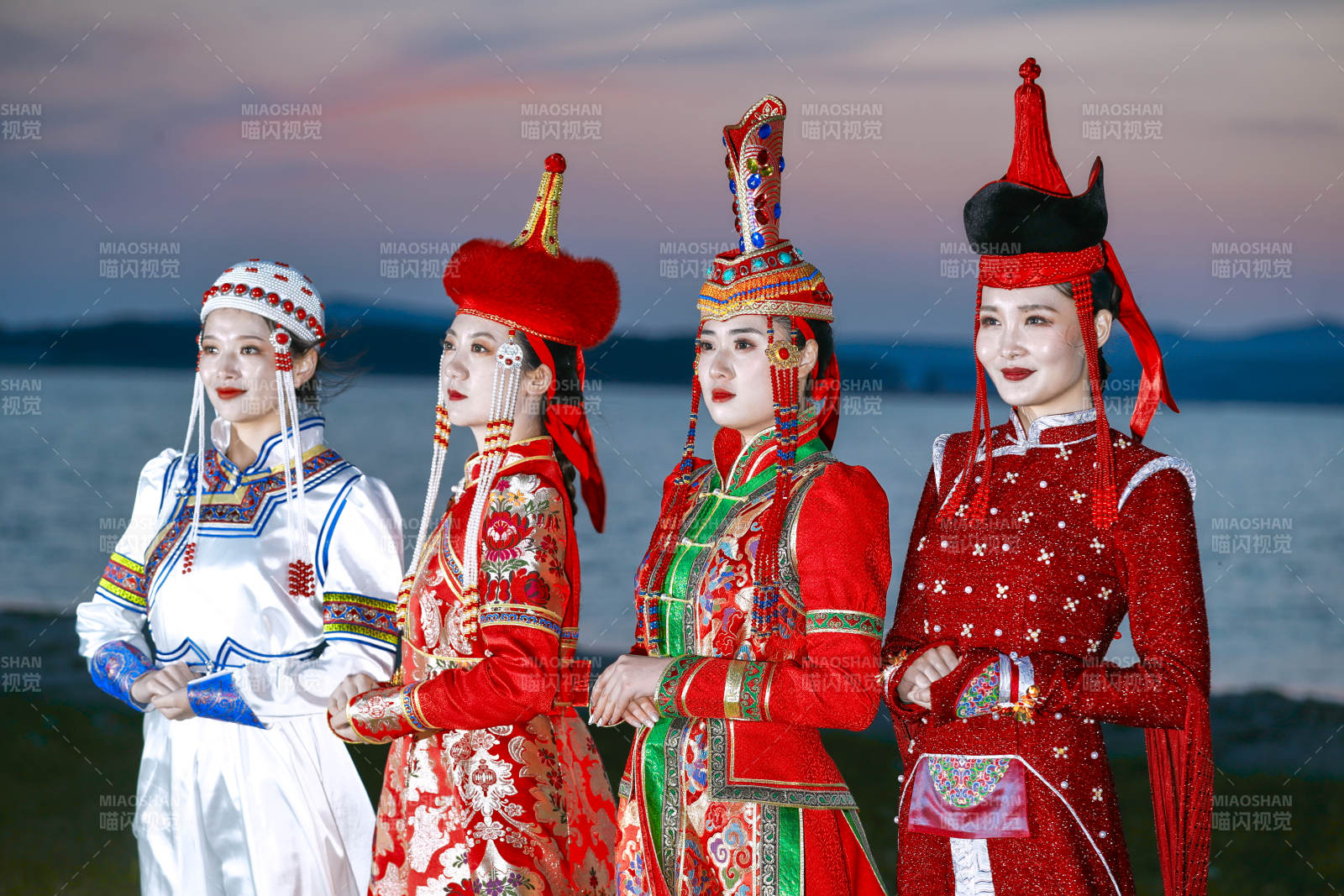 晚霞的草原湖畔穿蒙古族传统服饰的年轻女性图片