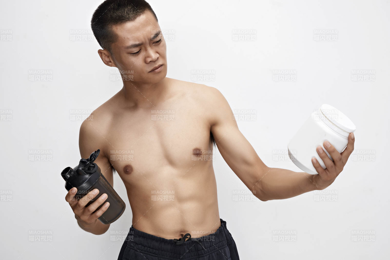 手持蛋白粉的身材匀称肌肉扎实的亚洲男性图片