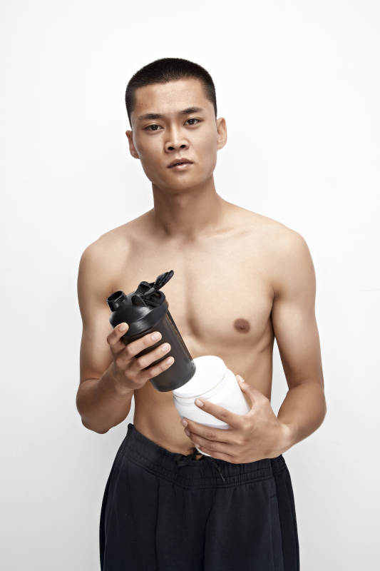 手持蛋白粉的身材匀称肌肉扎实的亚洲男性图片
