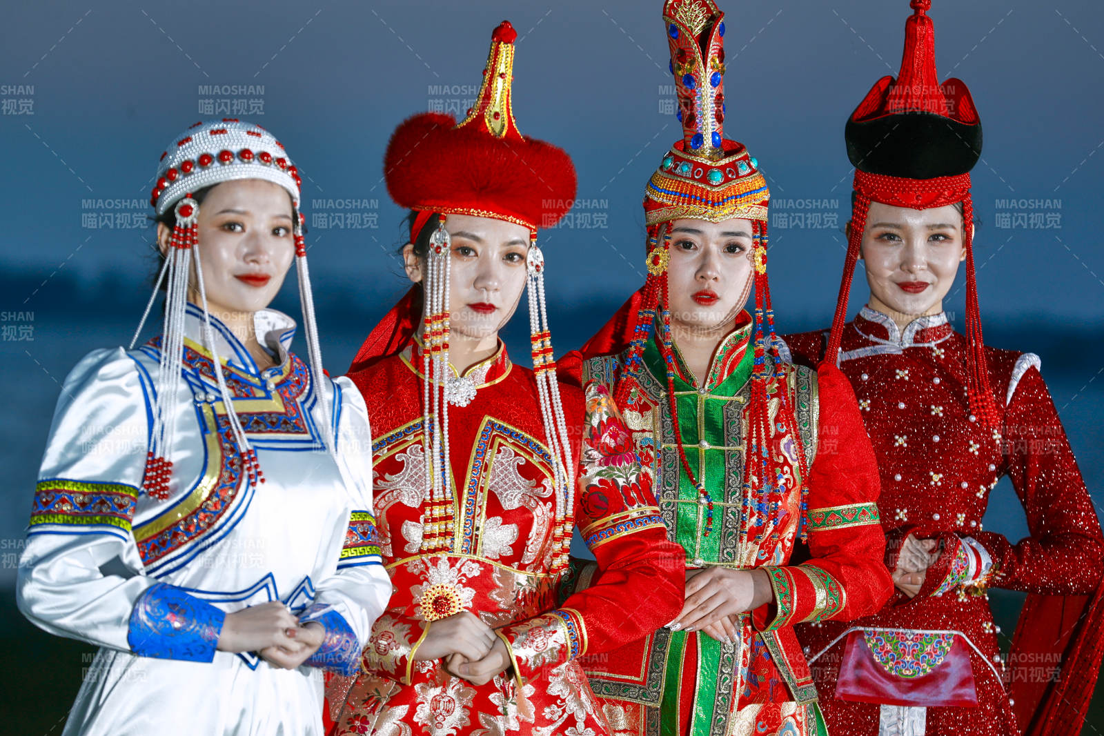 晚霞的草原湖畔穿蒙古族传统服饰的年轻女性图片