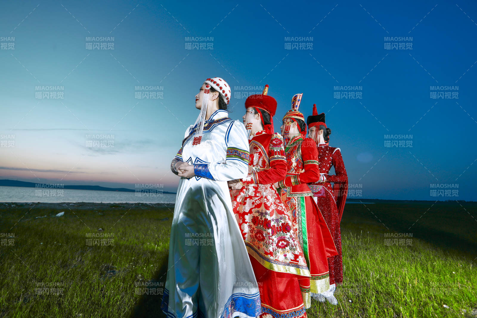 晚霞的草原湖畔穿蒙古族传统服饰的年轻女性图片