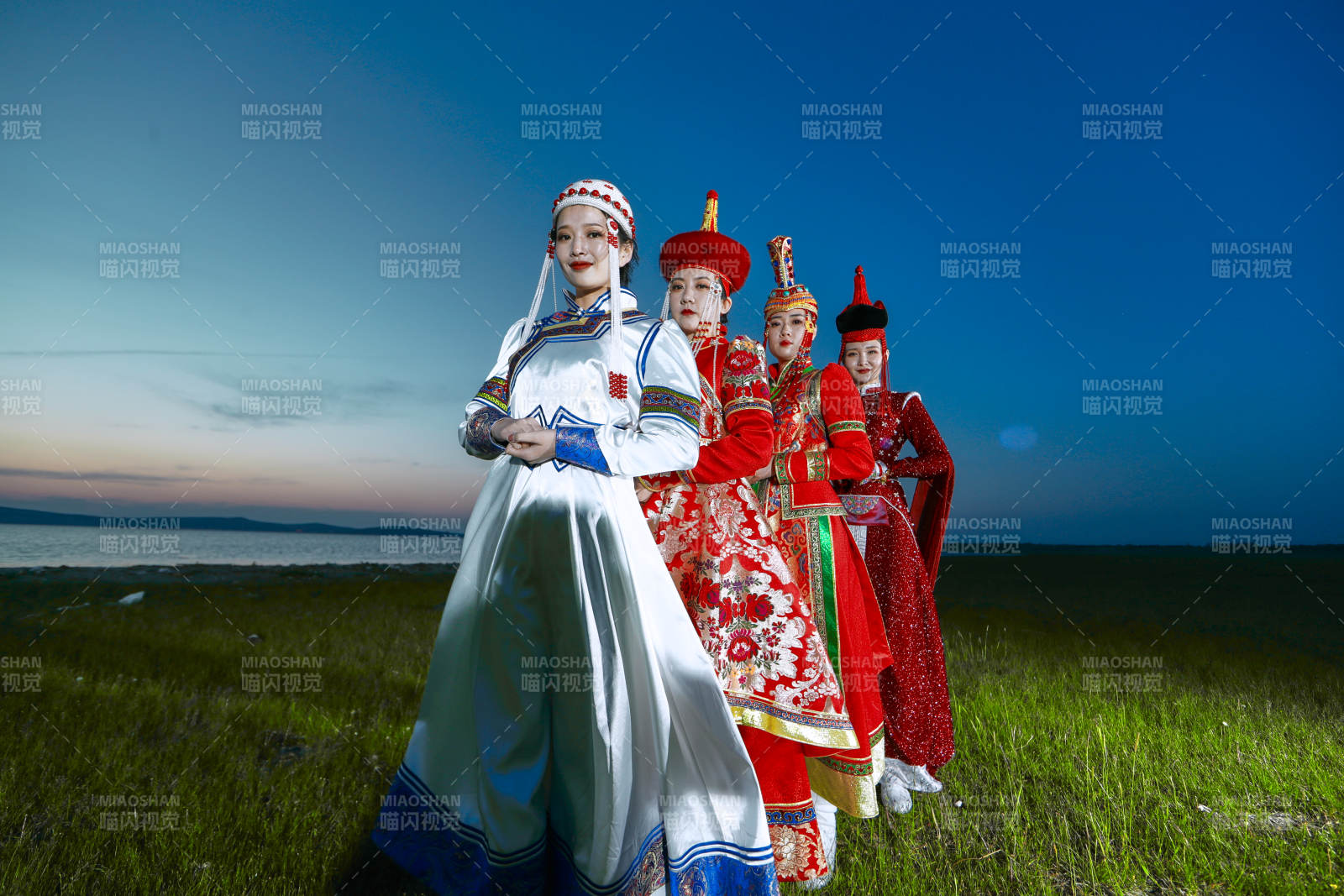 晚霞的草原湖畔穿蒙古族传统服饰的年轻女性图片