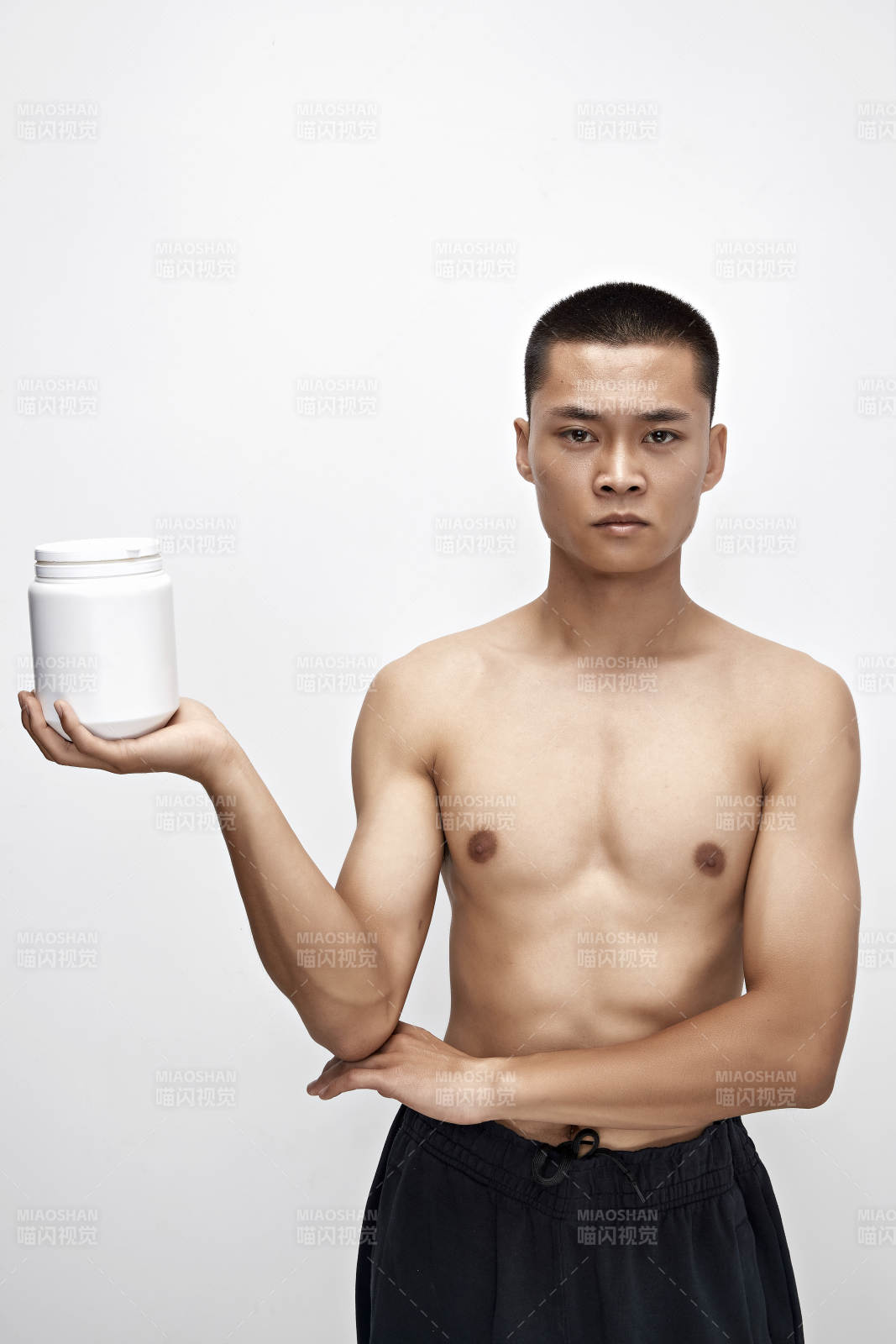 手持蛋白粉的身材匀称肌肉扎实的亚洲男性图片