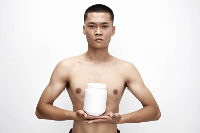 手持蛋白粉的身材匀称肌肉扎实的亚洲男性图片