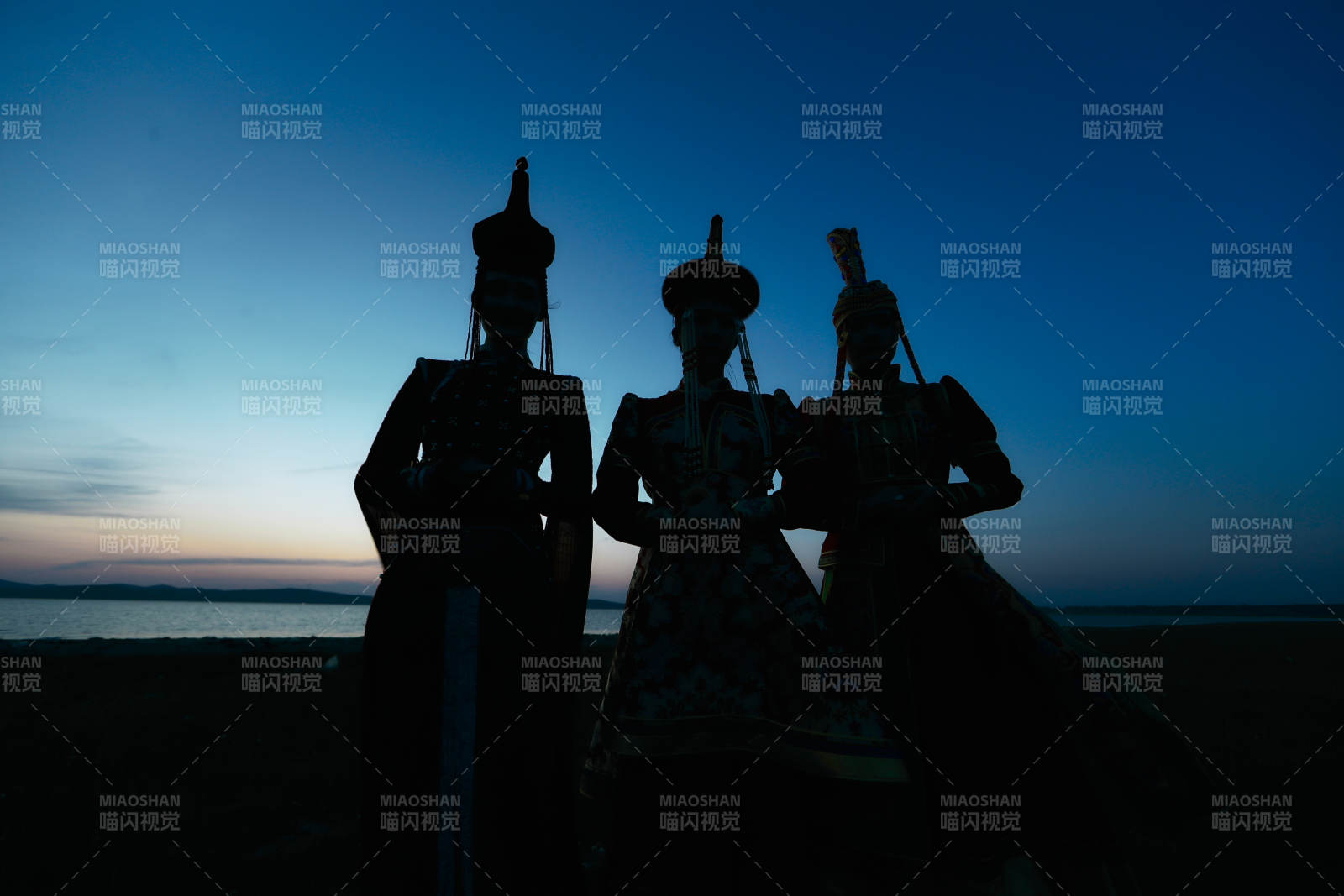 晚霞的草原湖畔穿蒙古族传统服饰的年轻女性图片