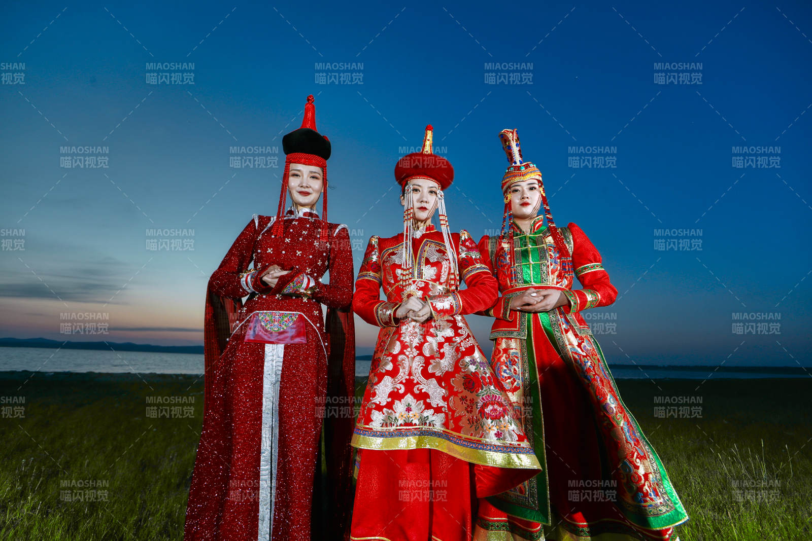 晚霞的草原湖畔穿蒙古族传统服饰的年轻女性图片