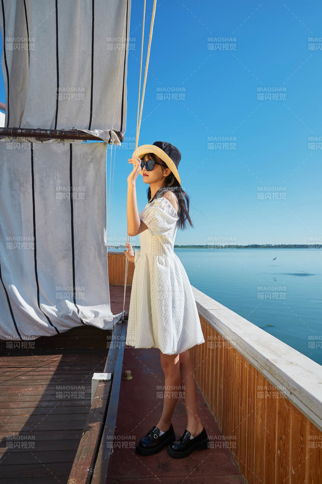 在湖畔木制帆船上的亚洲美女图片