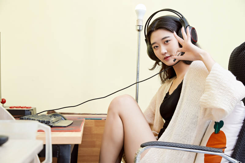 在家里坐在椅子上打游戏的美丽女孩图片