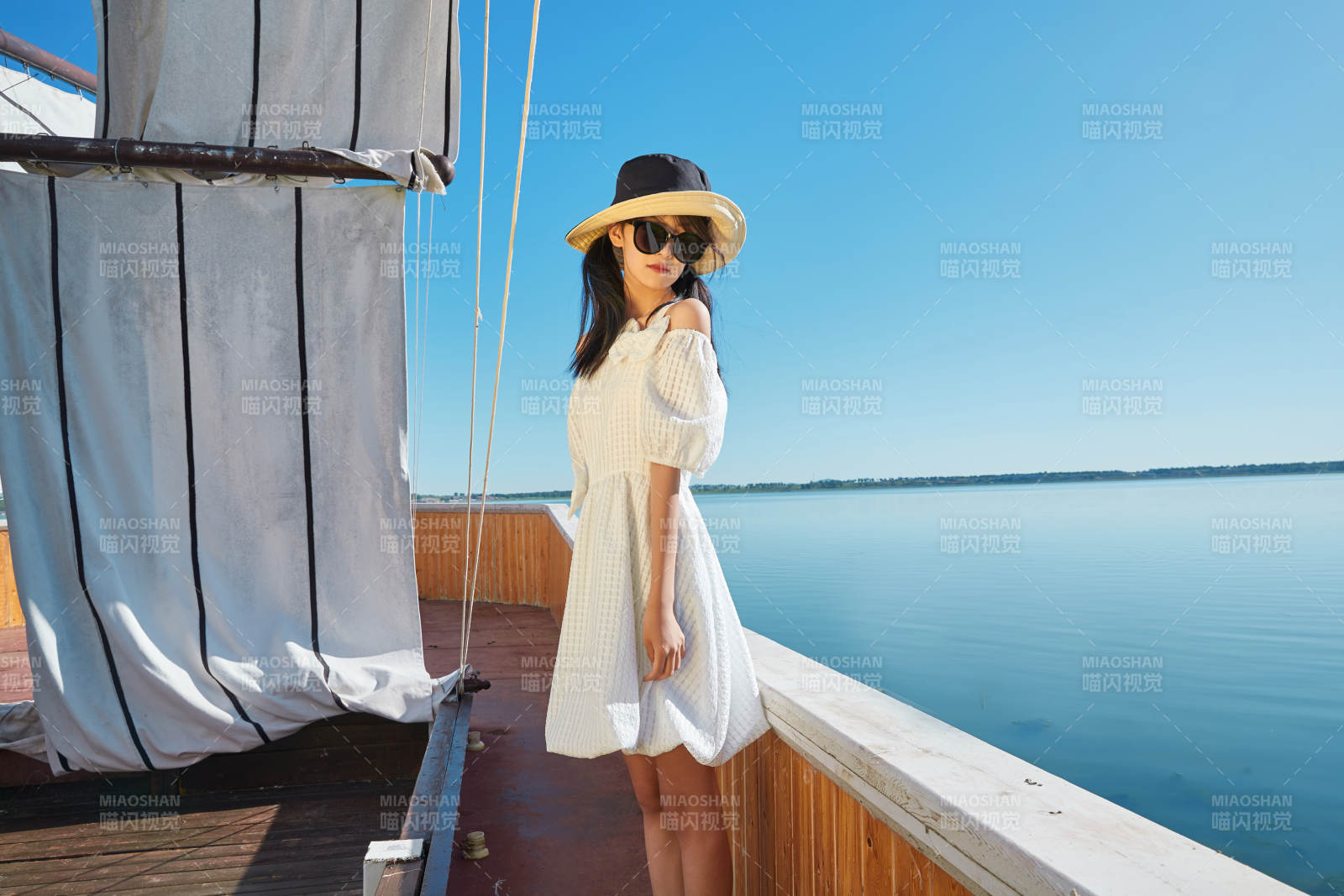 在湖畔木制帆船上的亚洲美女图片