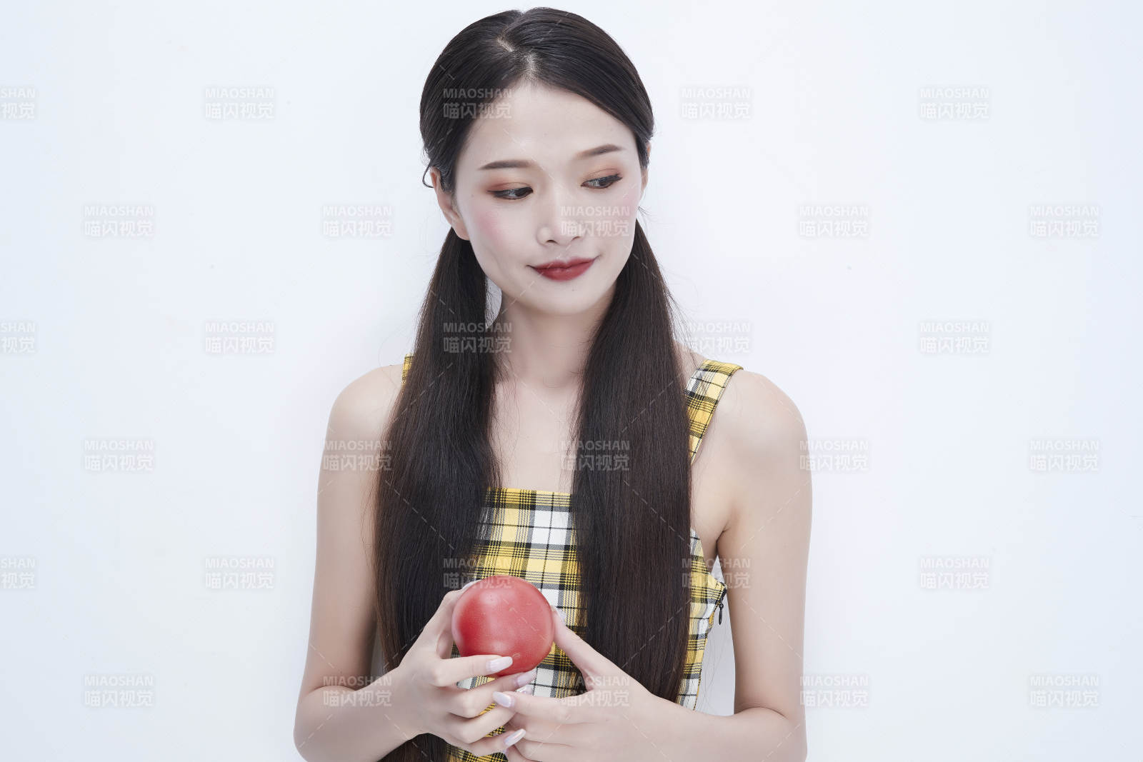 啃咬番茄身穿格子吊带裙的亚洲可爱少女人像图片