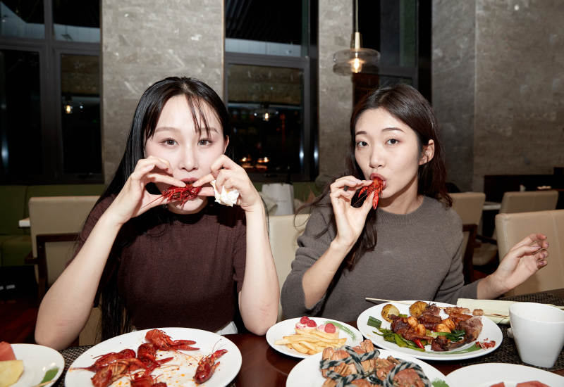 在酒店自助餐厅大吃特吃的亚洲可爱闺蜜少女图片