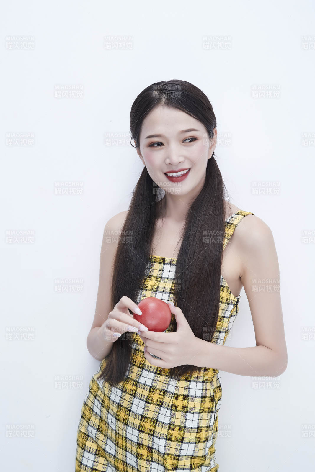 啃咬番茄身穿格子吊带裙的亚洲可爱少女人像图片