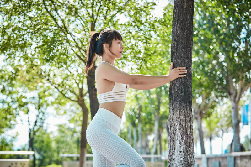 湖畔公园做瑜伽动作的亚洲年轻女性图片