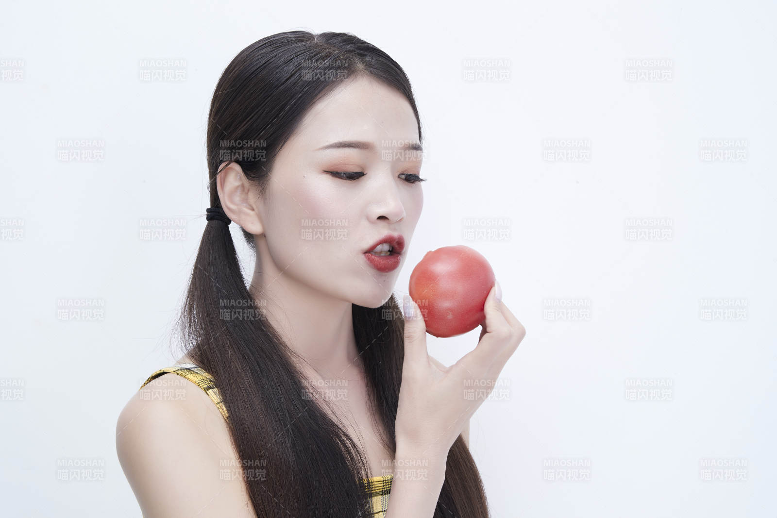 啃咬番茄身穿格子吊带裙的亚洲可爱少女人像图片