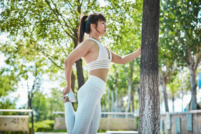 湖畔公园做瑜伽动作的亚洲年轻女性图片