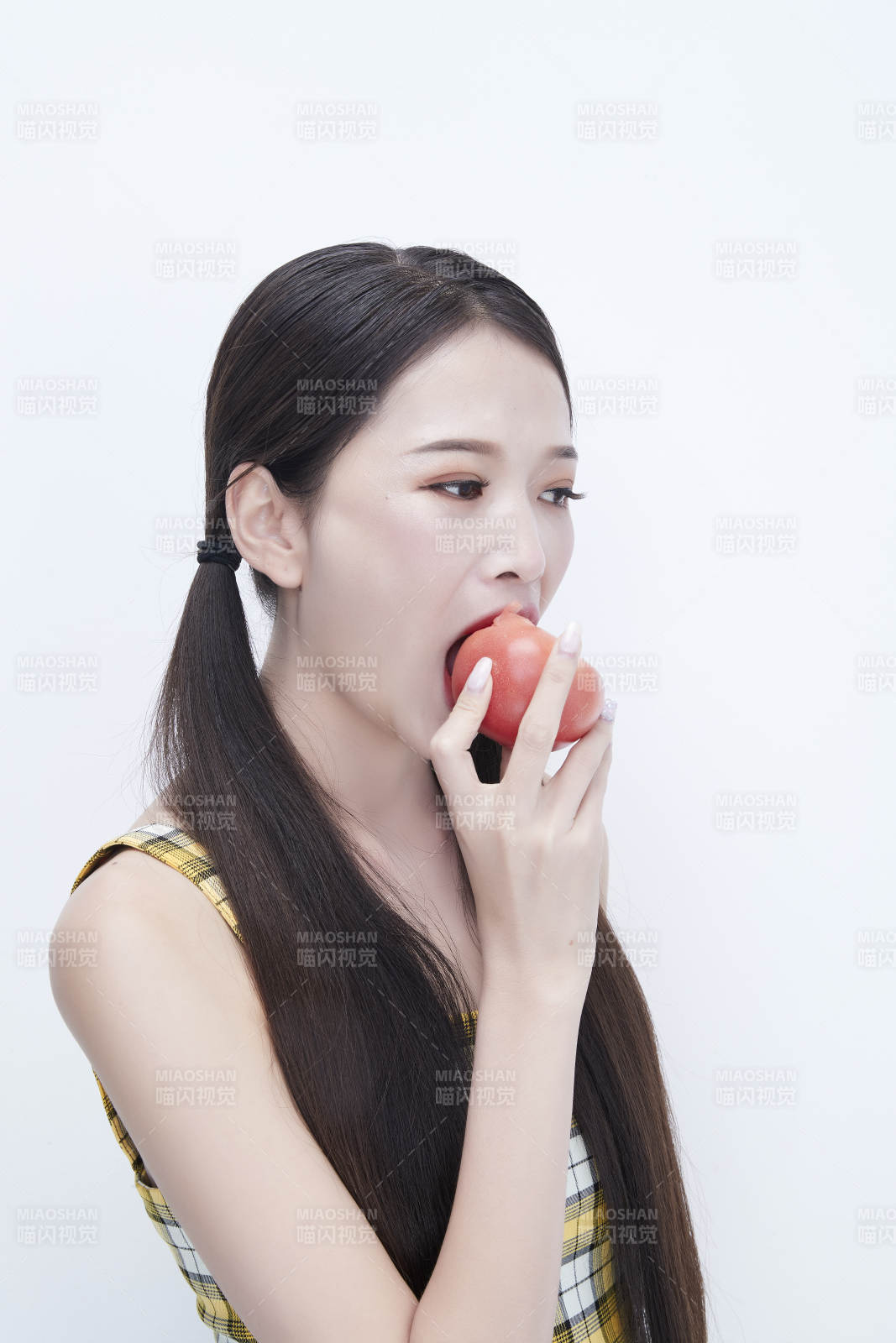 啃咬番茄身穿格子吊带裙的亚洲可爱少女人像图片