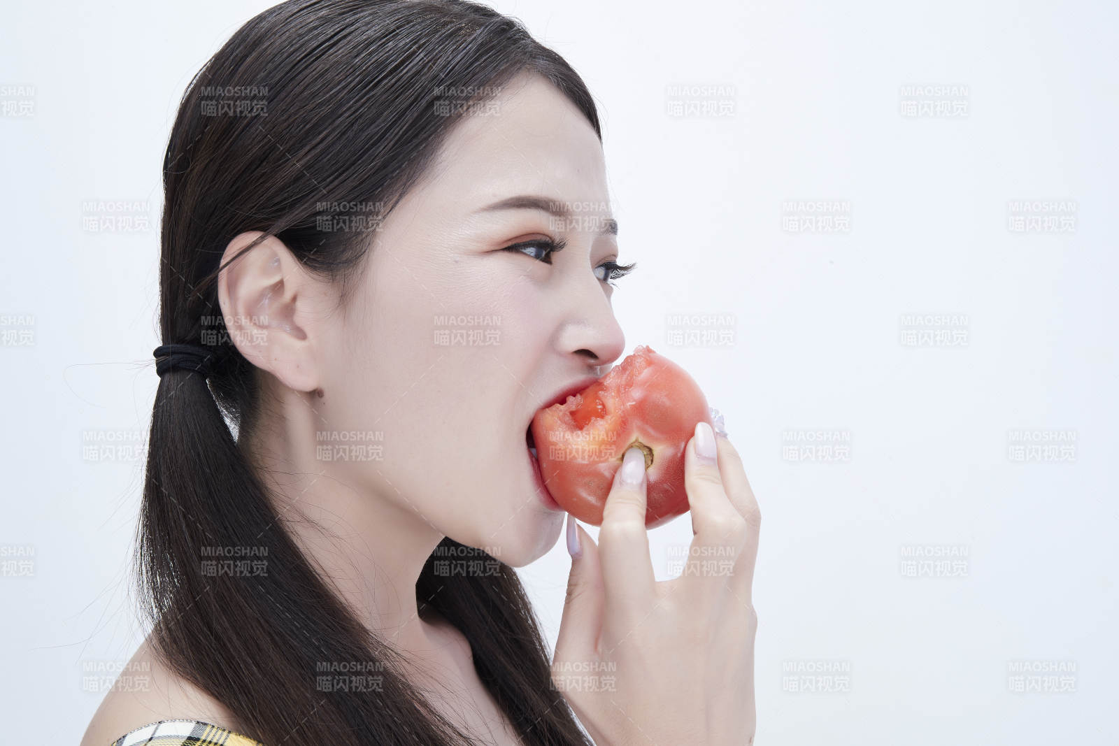 啃咬番茄身穿格子吊带裙的亚洲可爱少女人像图片