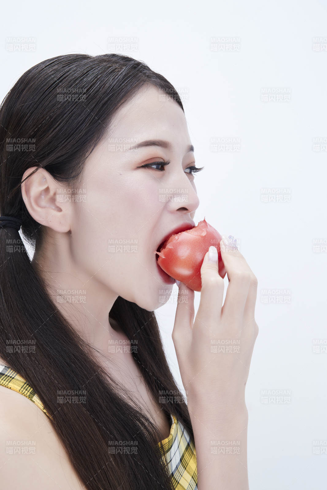 啃咬番茄身穿格子吊带裙的亚洲可爱少女人像图片