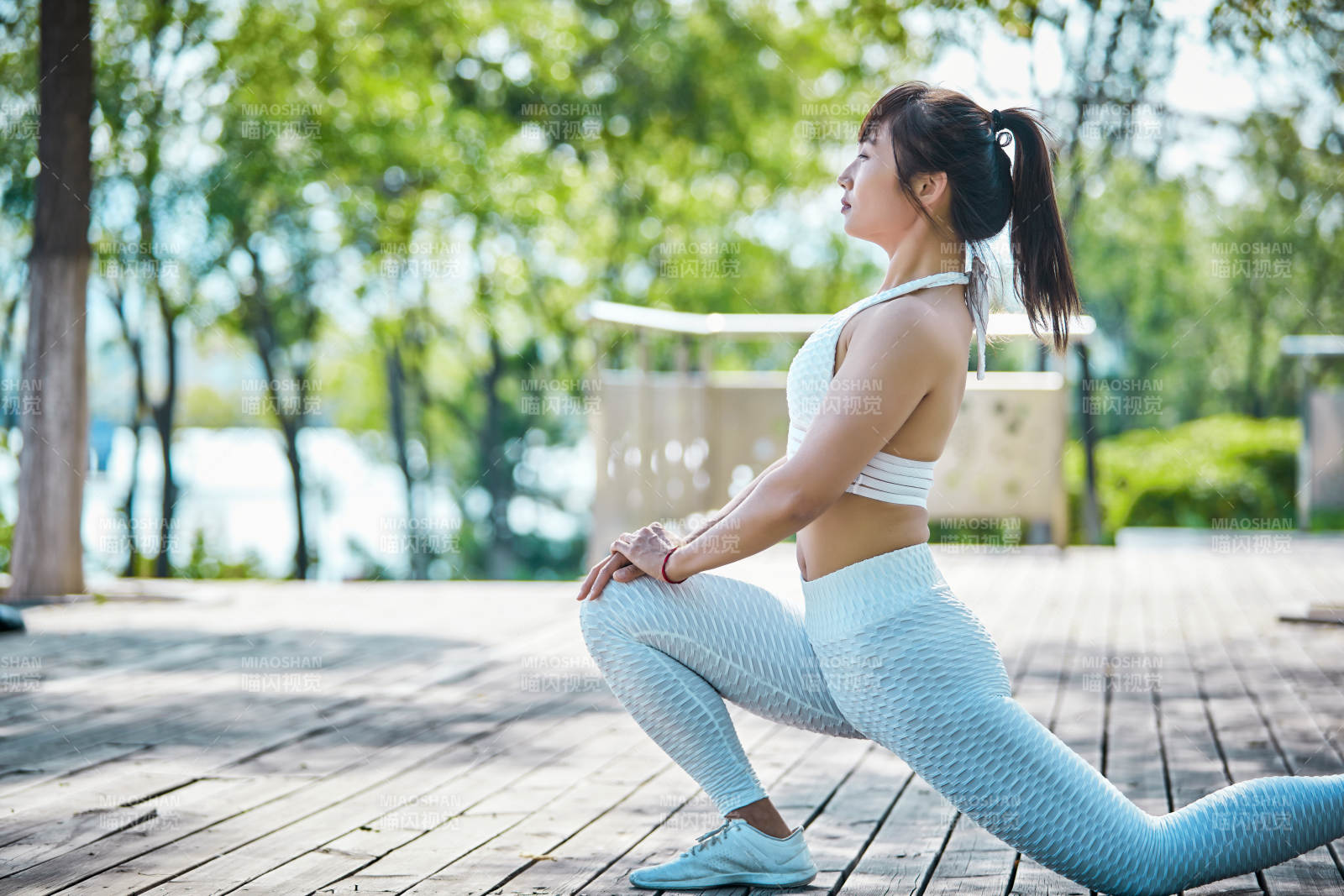 湖畔公园做瑜伽动作的亚洲年轻女性图片