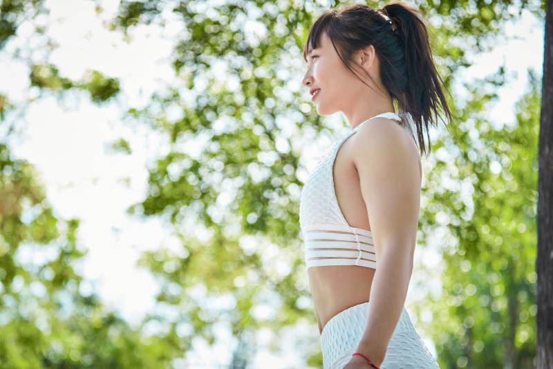 湖畔公园做瑜伽动作的亚洲年轻女性图片