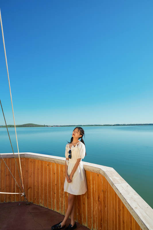 在湖畔木制帆船上的亚洲美女图片