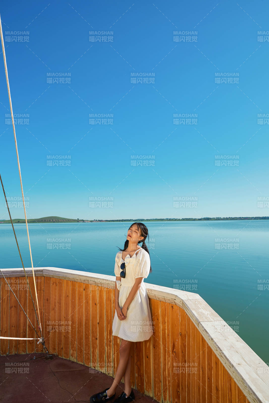 在湖畔木制帆船上的亚洲美女图片