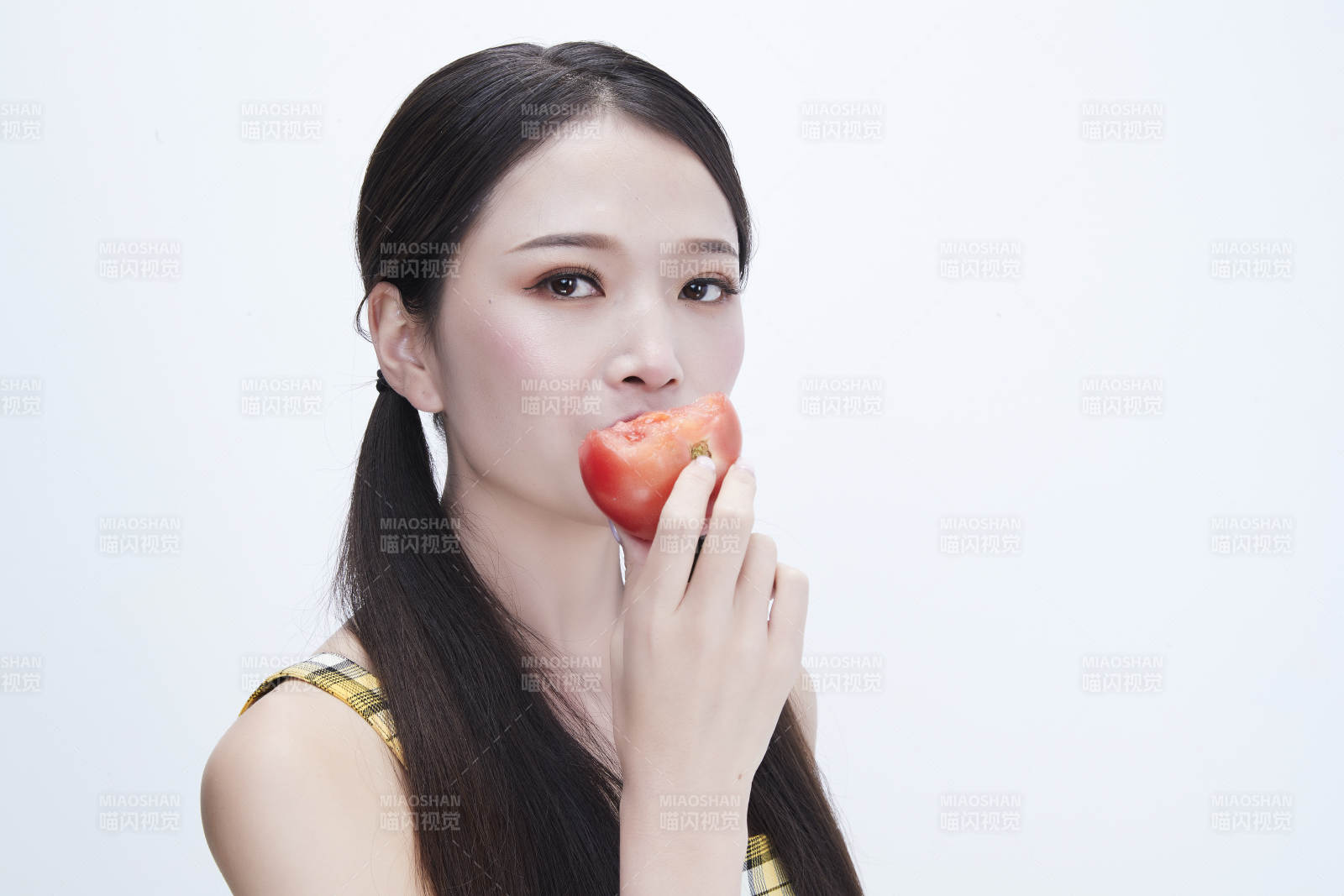 啃咬番茄身穿格子吊带裙的亚洲可爱少女人像图片