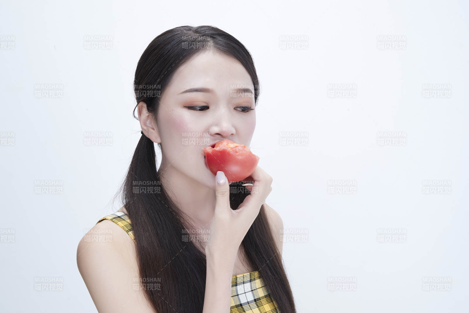 啃咬番茄身穿格子吊带裙的亚洲可爱少女人像图片