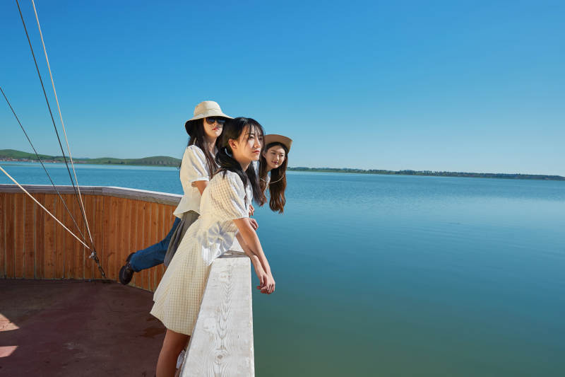 在湖畔木制帆船上的亚洲美女闺蜜图片