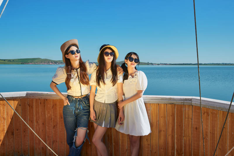 在湖畔木制帆船上的亚洲美女闺蜜图片