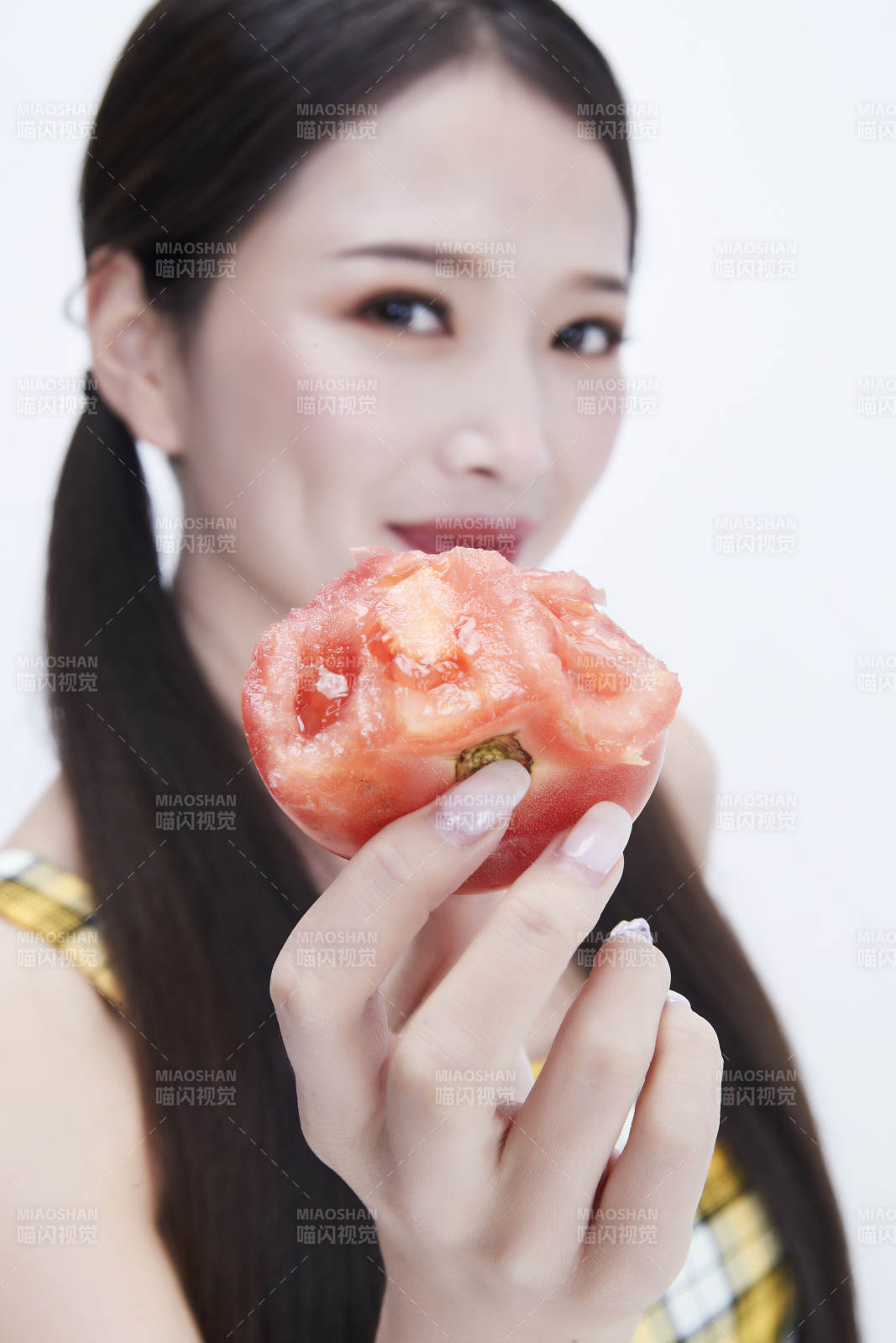 啃咬番茄身穿格子吊带裙的亚洲可爱少女人像图片