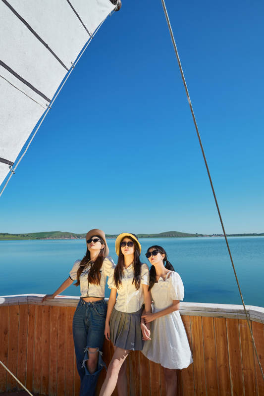 在湖畔木制帆船上的亚洲美女闺蜜图片