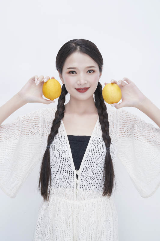 手拿柠檬身穿镂空连衣裙的亚洲可爱少女人像图片
